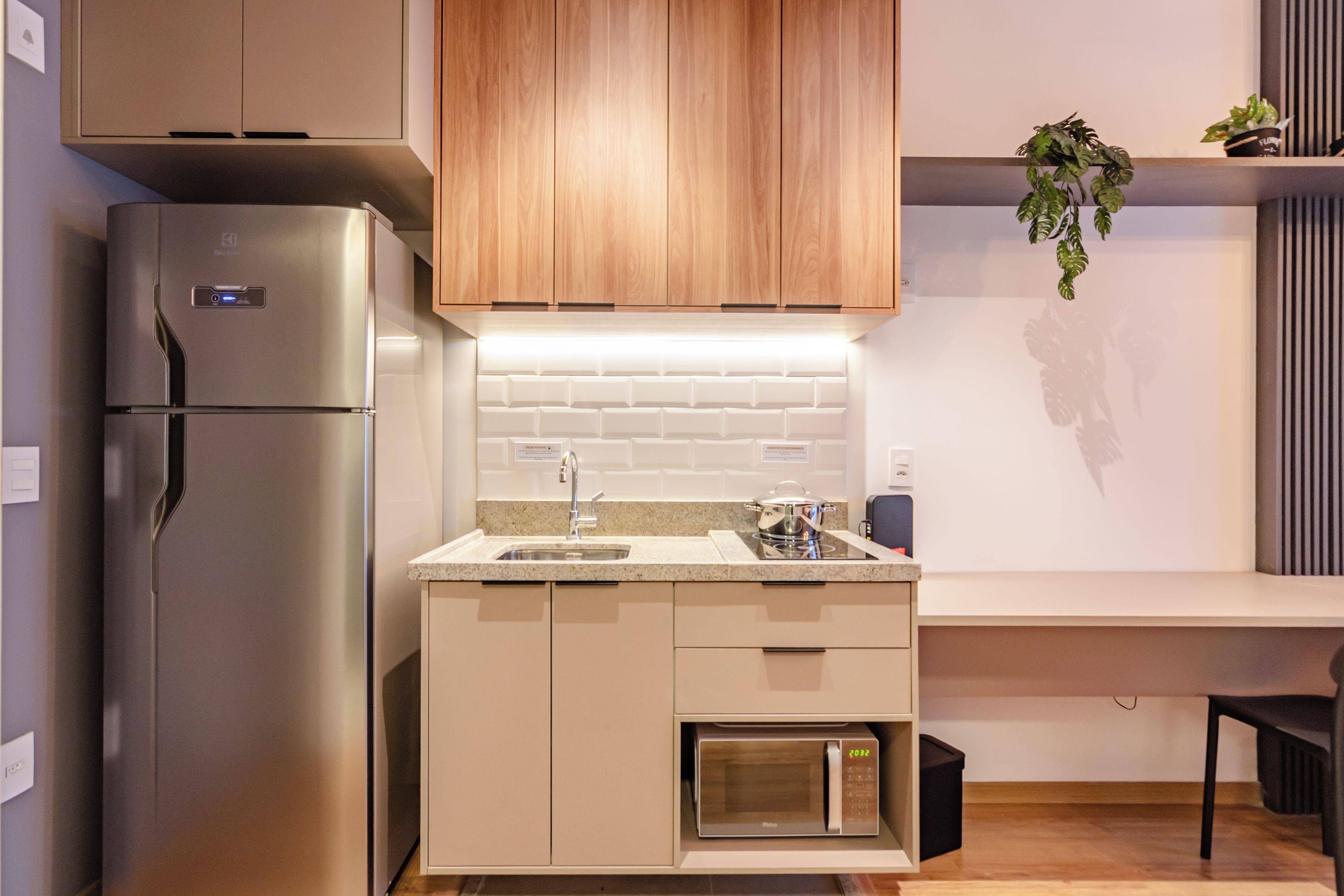 Una cocina moderna con refrigerador integrado, microondas y pileta.