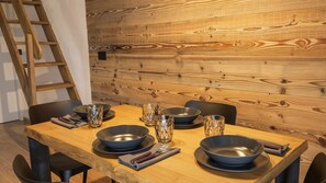 A dining area with a wooden table, black chairs, and metal bowls. - Casa Quaranta - Two Bedroom Apartment, Sleeps 4 (Ponte di legno)