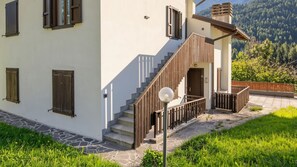 A modern house with a stone staircase, wooden railings, and a view of a forested mountain. - Casa Quaranta - Two Bedroom Apartment, Sleeps 4 (Ponte di legno)