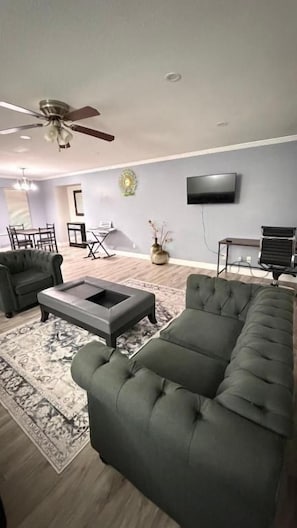A modern living room with a sofa, armchair, and coffee table. - J & J Dream Villa Ltd (Abbotsford)