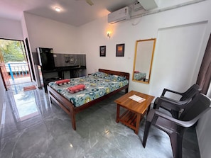 A hotel room with a bed, a desk, a chair, a mirror, and an air conditioning unit. - Room-peaceful Stay Private Studio R-11 1 (Arambol)