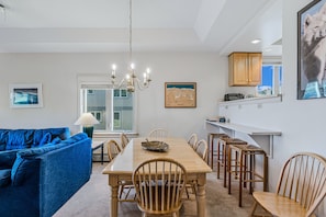 A modern kitchen with a dining area, wooden furniture, and a chandelier. - Solitude Ski-In/Ski-Out Condo with Pool & Hot Tub (Ludlow)