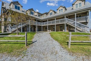 A multi-story building with a central staircase leading to a covered porch area. - Solitude Ski-In/Ski-Out Condo with Pool & Hot Tub (Ludlow)