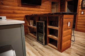 Ein kleiner Küchenbereich mit Holzschränken, einem Kühlschrank und einer Arbeitsplatte.