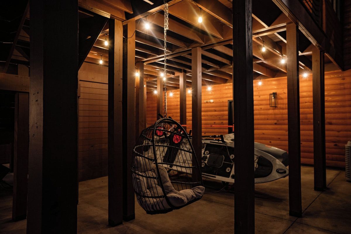 Ein Holzblockhaus-Interieur mit Hängesessel, einem Auto und Holzbalken.