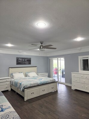 A bedroom with a bed, dresser, and ceiling fan.