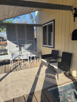 An outdoor patio with a table and chairs, a wicker sofa, a window, and a lamp. - Peaceful 1-bedroom back house with AC in charming Versailles (Versailles)