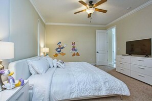 A bedroom with a bed, a ceiling fan, a television, and a dresser. - 5BR Reunion home | Pool, spa & Disney rooms (Kissimmee)