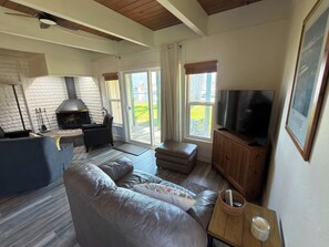 Een woonkamer met een open haard, een televisie en een bank.