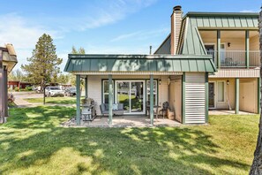 A two-story house with a covered patio area, a barbecue grill, and a view of the backyard. - Tahoe Keys Condo, 2 bedrooms with Boat Dock! (South Lake Tahoe)