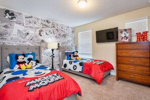 A bedroom with two beds, each adorned with Mickey Mouse-themed bedding. - 5BR home near Disney | Pool & Mickey room (Kissimmee)