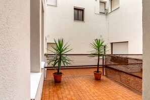 A balcony with two potted plants and a tiled floor. - Apartment 'a pie de playa en Ris' (Noja)