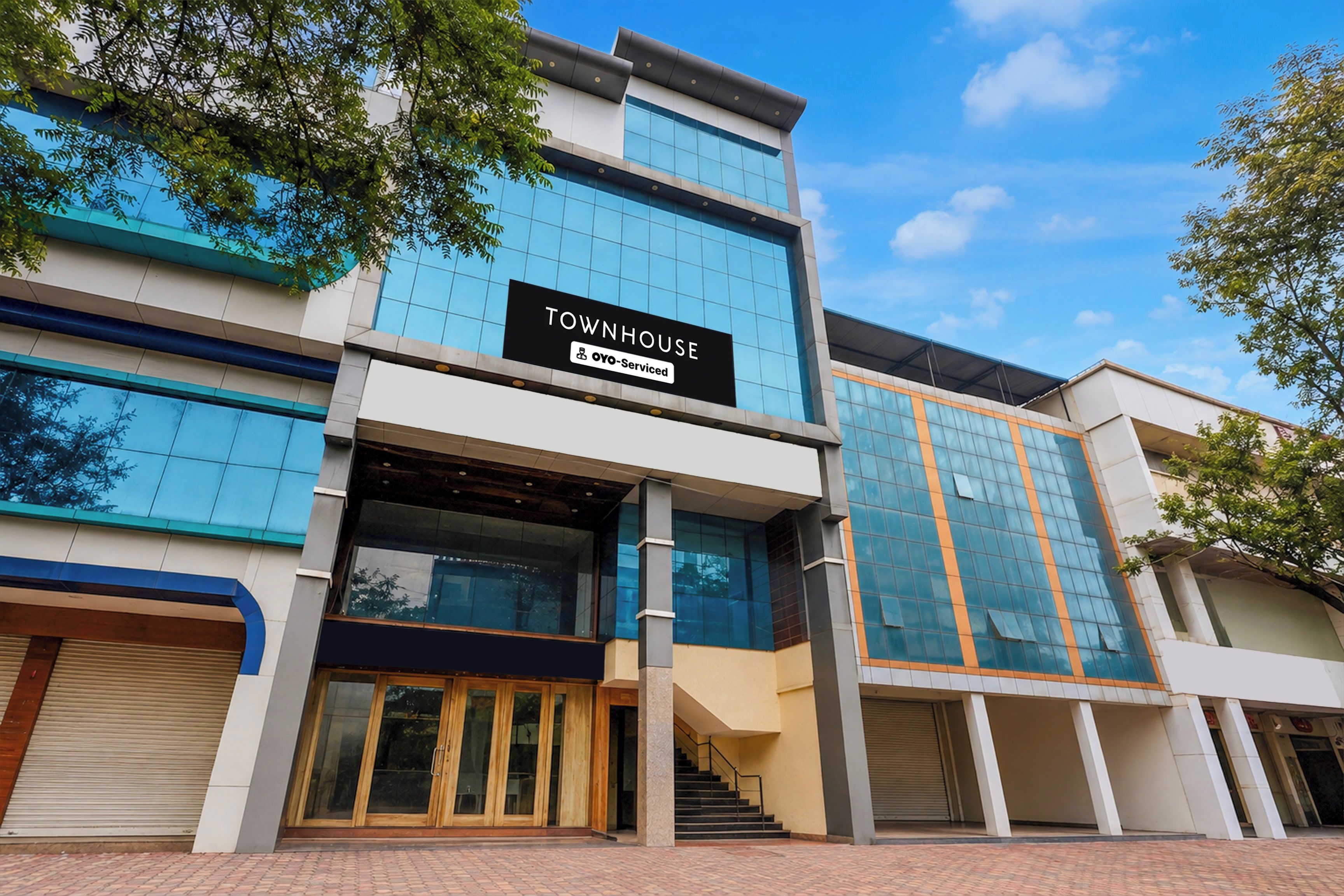 A modern building with a sign reading 'TOWNHOUSE OYO-Serviced'.