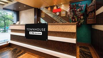 A reception desk with a sign reading 'TOWNHOUSE' and 'YO-Serviced'.