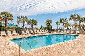 A swimming pool with lounge chairs and palm trees. - Myrtle Beach Oceanfront Retreat 2 BR Condo Yachtsman S706 (Myrtle Beach)