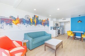 Ein modernes Wohnzimmer mit einer Couch, einem Couchtisch und einem farbenfrohen Stadtbild-Wandgemälde.