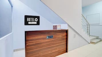 A hotel reception desk with a sign indicating it is serviced by OYO.