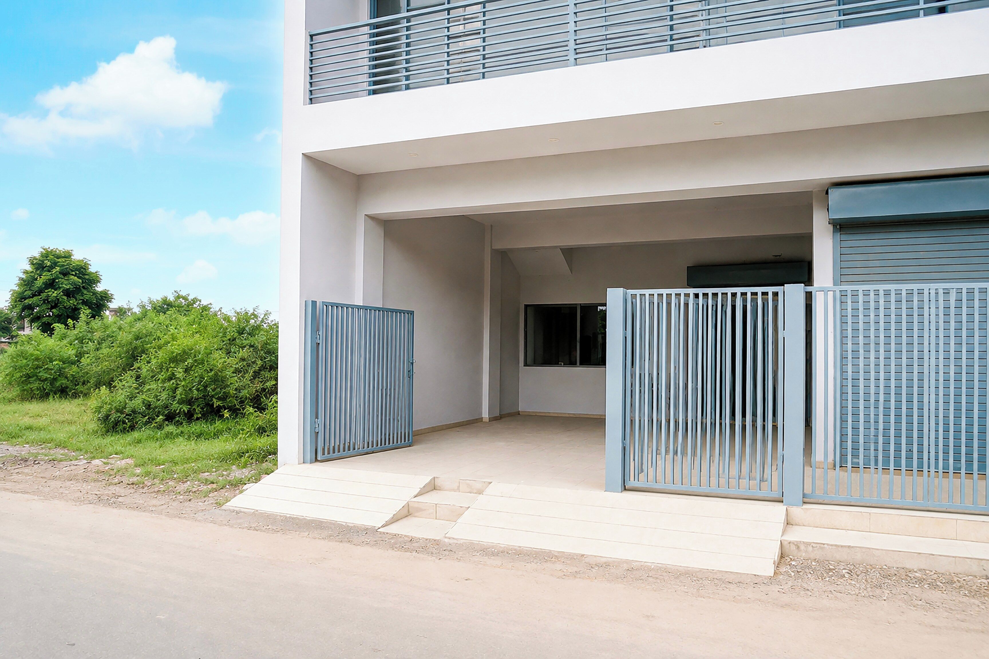 Un edificio moderno con techo plano, balcón y entrada protegida.