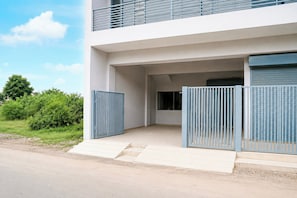 A modern building with a flat roof, a balcony, and a gated entrance. - Hotel O Threeke Highway Ludhiana (Ludhiana)