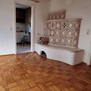 A room with a wooden parquet floor, a white wall, and a built-in bench with decorative panels. - Großes Haus in Sandweier für bis zu 16 Gäste – 8 Schlafzimmer (Baden-Baden)