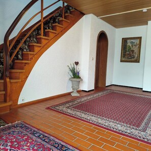 A staircase with wooden railings and a patterned carpet. - Großes Haus in Sandweier für bis zu 16 Gäste – 8 Schlafzimmer (Baden-Baden)