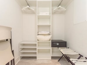 A walk-in closet with white shelves, a storage unit, and a chair. - Panoramic Ocean View Entire Rental Unit - 2bed/2bath Hotel Suite, Hollywood, FL (Hollywood)