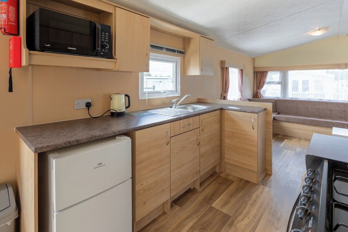 A compact kitchen with a microwave, a coffee maker, and a stove.