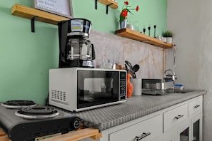 Eine Küche mit Kaffeemaschine, Mikrowelle und Gaskochfeld.