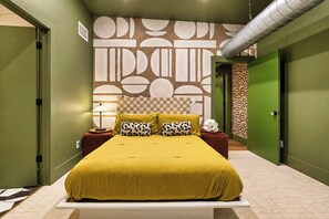 A bedroom with a large bed, a patterned wall, and green doors. - Stunning Penthouse | Luxe • Sleeps 19 • Downtown! (Frankfort)