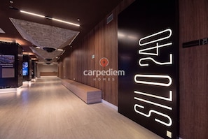 A modern interior with a reception desk, wooden paneling, and a large illuminated sign reading 'carpediem homes'. - Silo 240 in Recife Antigo With Two Leisure Rooftops, Pools, Gym, Coworking and Sea View, Near Marco Zero by Carpediem (Recife)
