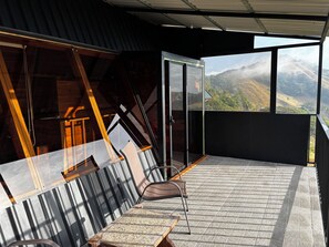 A balcony with a view of a mountainous landscape, a chair, and a table. - Torremar House Monteverde (Provincia de Puntarenas)