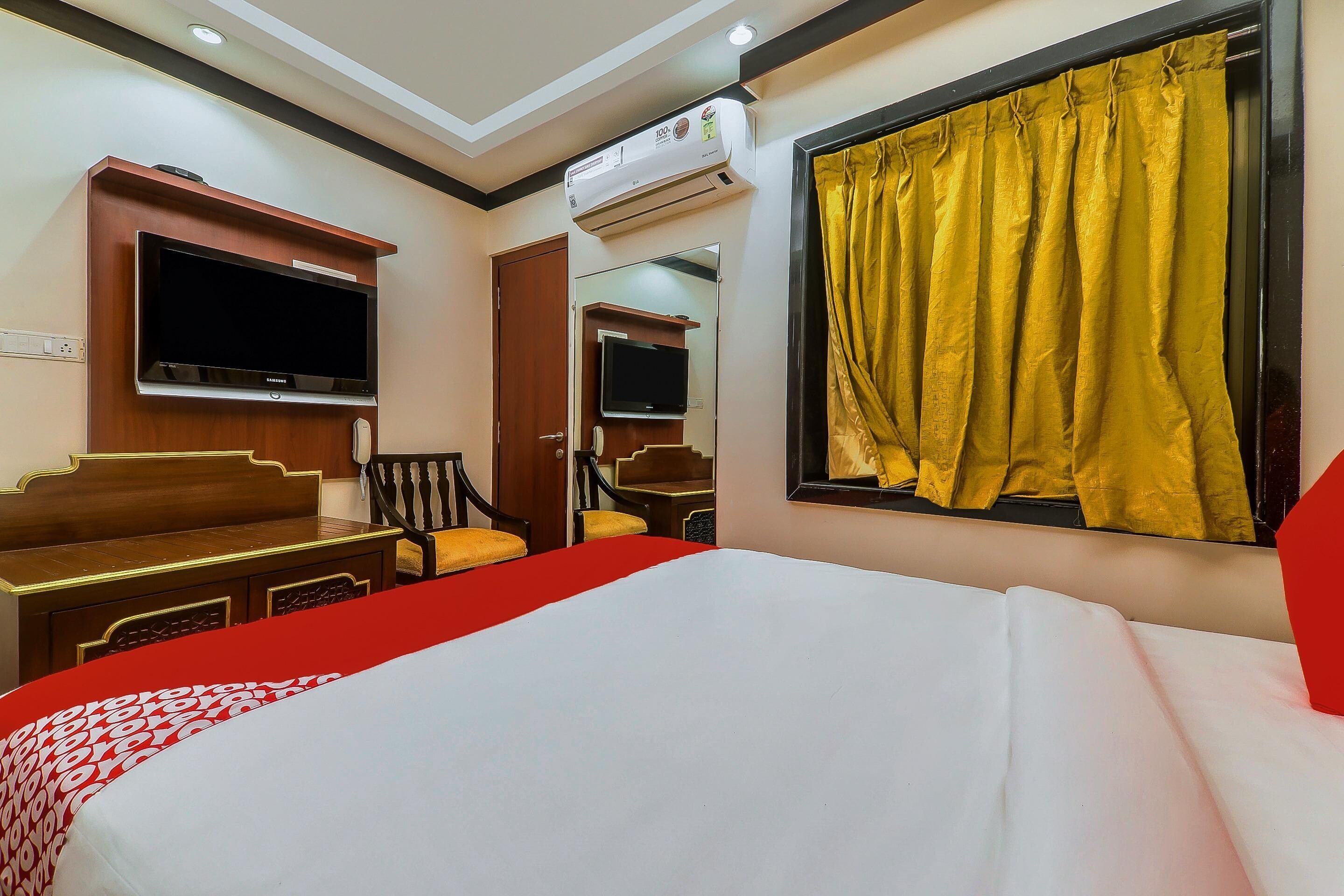 A hotel room with a bed, a television, a desk, and a chair.