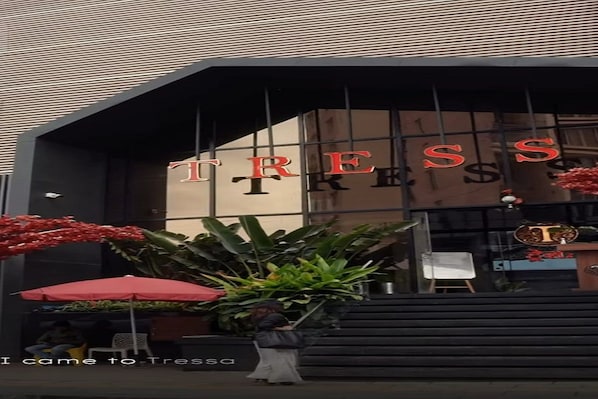 A building entrance with the name 'TRESS' displayed prominently.