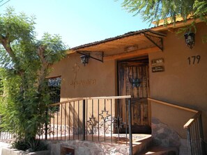 A building with a stone facade, a wooden door, and a metal staircase with a railing.