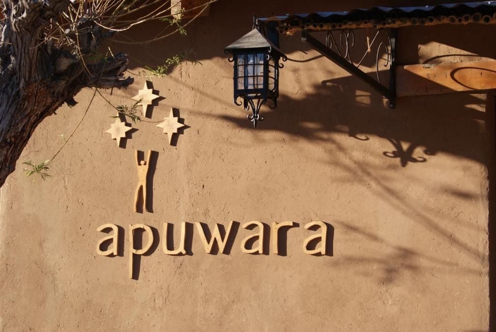 A sign with the word 'apuwara' and decorative stars on a sandy surface.