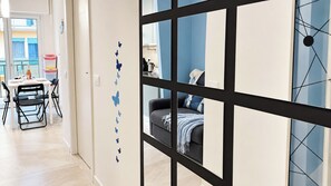 A modern interior with a dining area, a sofa, and a wall with butterfly decals. - Coccole Sottomarina by Ca-Sa Check (Chioggia)