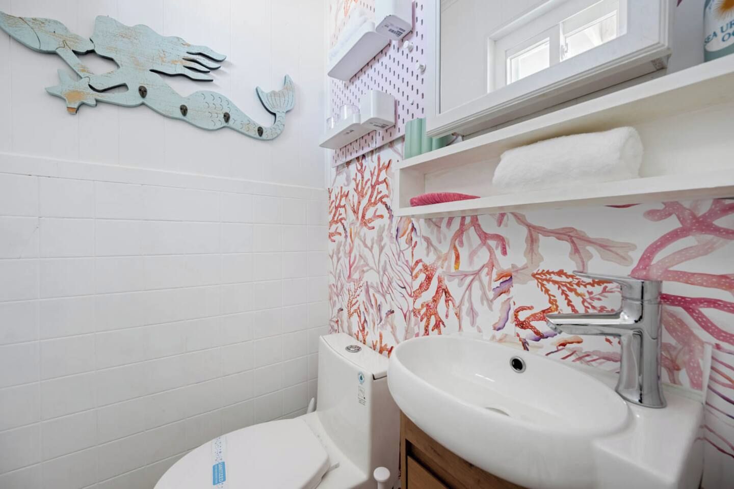 A bathroom with a white toilet, a white sink, and a shower area.