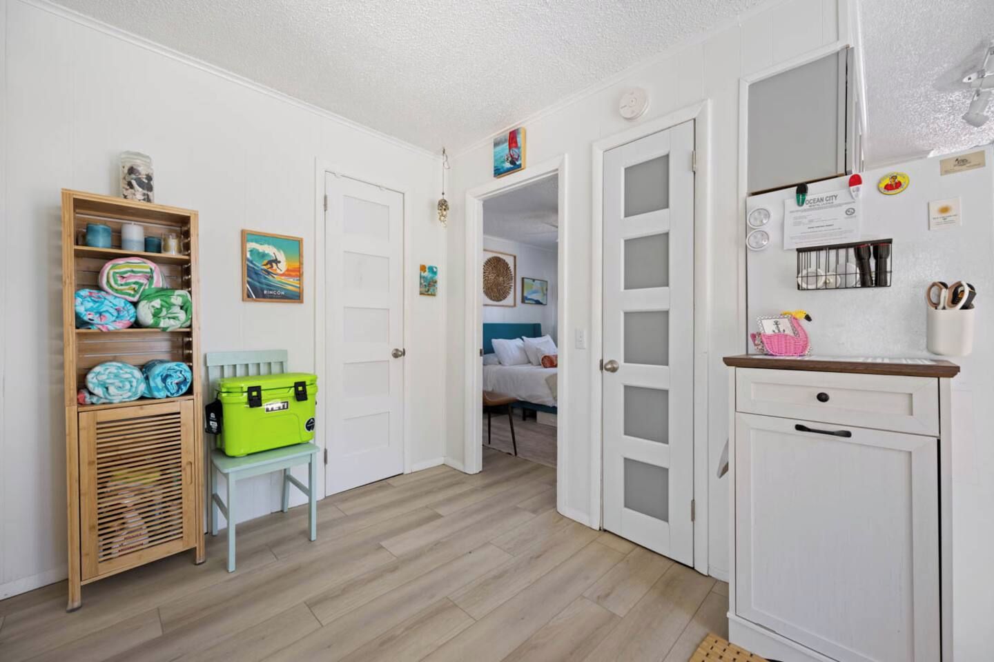 Een gang met een houten plank, een groene opbergdoos en een bed op de achtergrond.