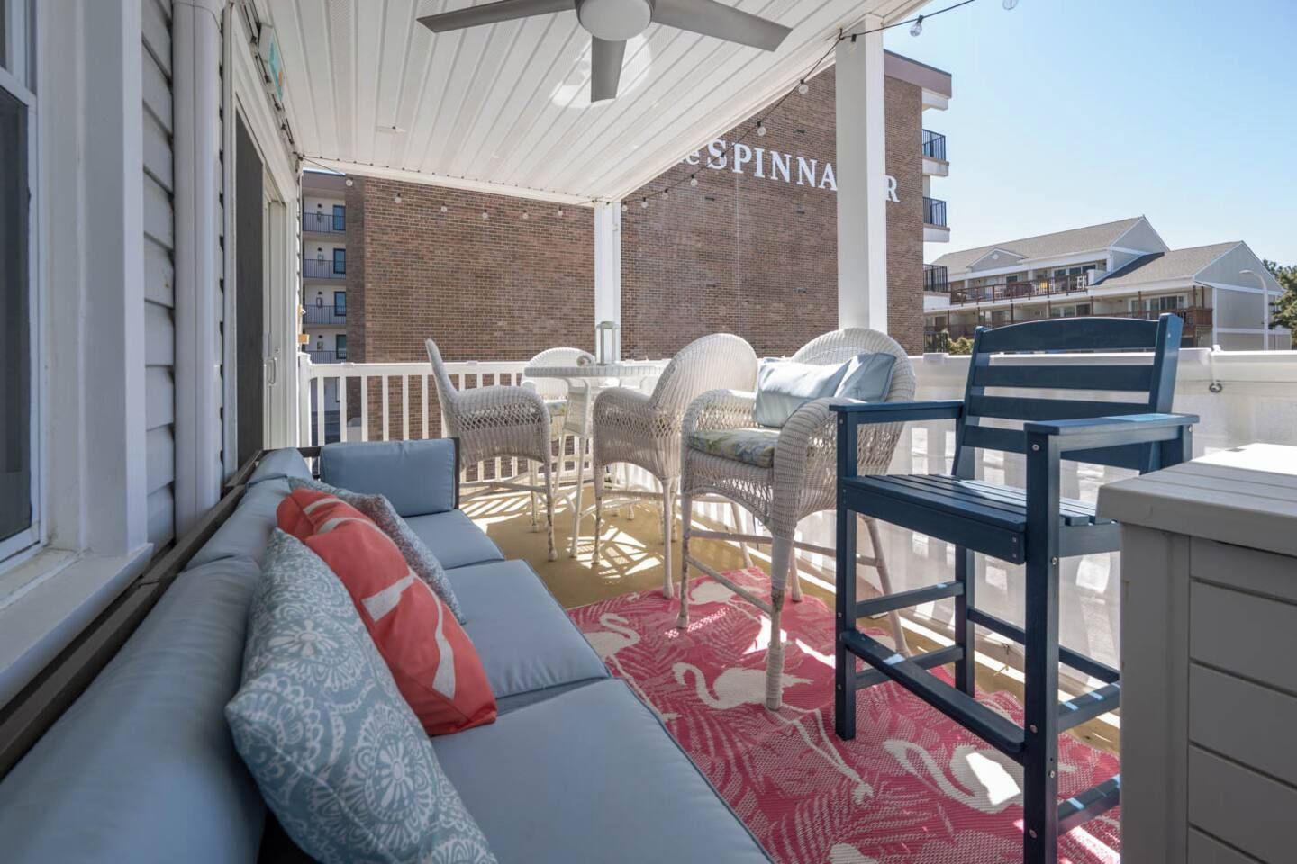 A covered outdoor seating area with a sofa, chairs, and a table.