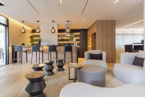 A modern living room with a bar area, seating, and a coffee table. - Nik by Bhomy (São Paulo)