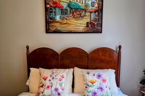A bed with floral-patterned pillows and a wooden headboard.