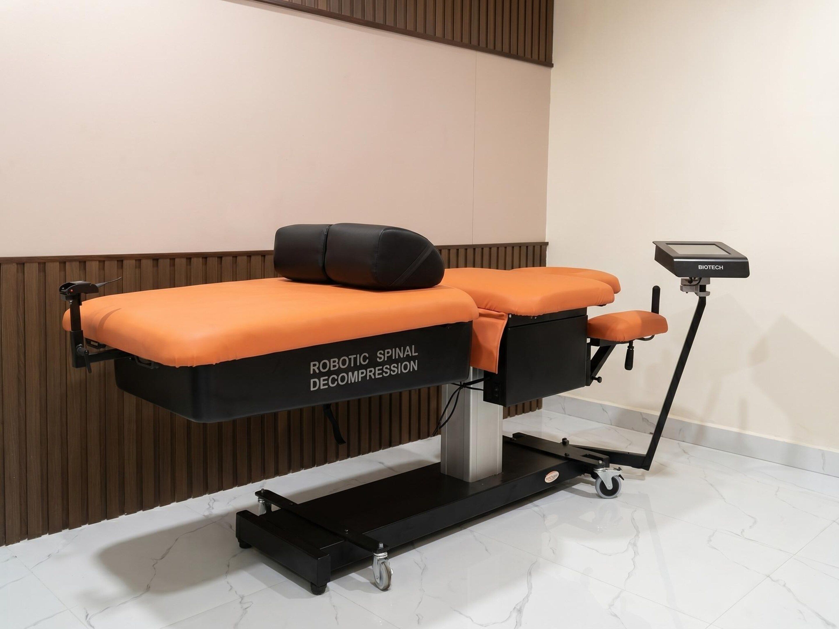 A medical examination table with a robotic spinal decompression unit.