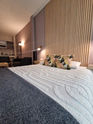 Ein Hotelzimmer mit einem Bett, einem Schreibtisch und einer Küchenzeile.