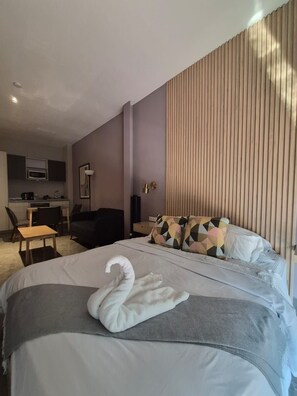 Ein Hotelzimmer mit einem Bett, einem Schreibtisch, einem Stuhl, einer Mikrowelle und einer Lampe.