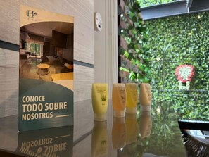 Ein Hotel-Rezeptionsbereich mit einer Glasvitrine für Spa-Produkte und einem Plakat, das das Hotel bewirbt.