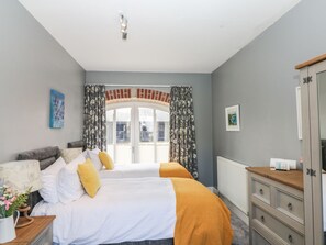 Ein Schlafzimmer mit zwei Betten, einem Schminktisch und einer Heizung.