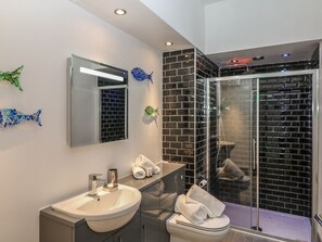 Ein modernes Badezimmer mit Duschkabine aus Glas, Waschbecken und Toilette.