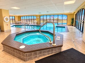 An indoor swimming pool with a hot tub, surrounded by large windows and a view of a bridge. - Cute 2 Bed 2 Bath at Harbor Place - Fall Specials! (Orange Beach)
