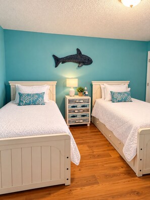 A bedroom with two beds, a nightstand, a lamp, and a wall decoration. - Cute 2 Bed 2 Bath at Harbor Place - Fall Specials! (Orange Beach)