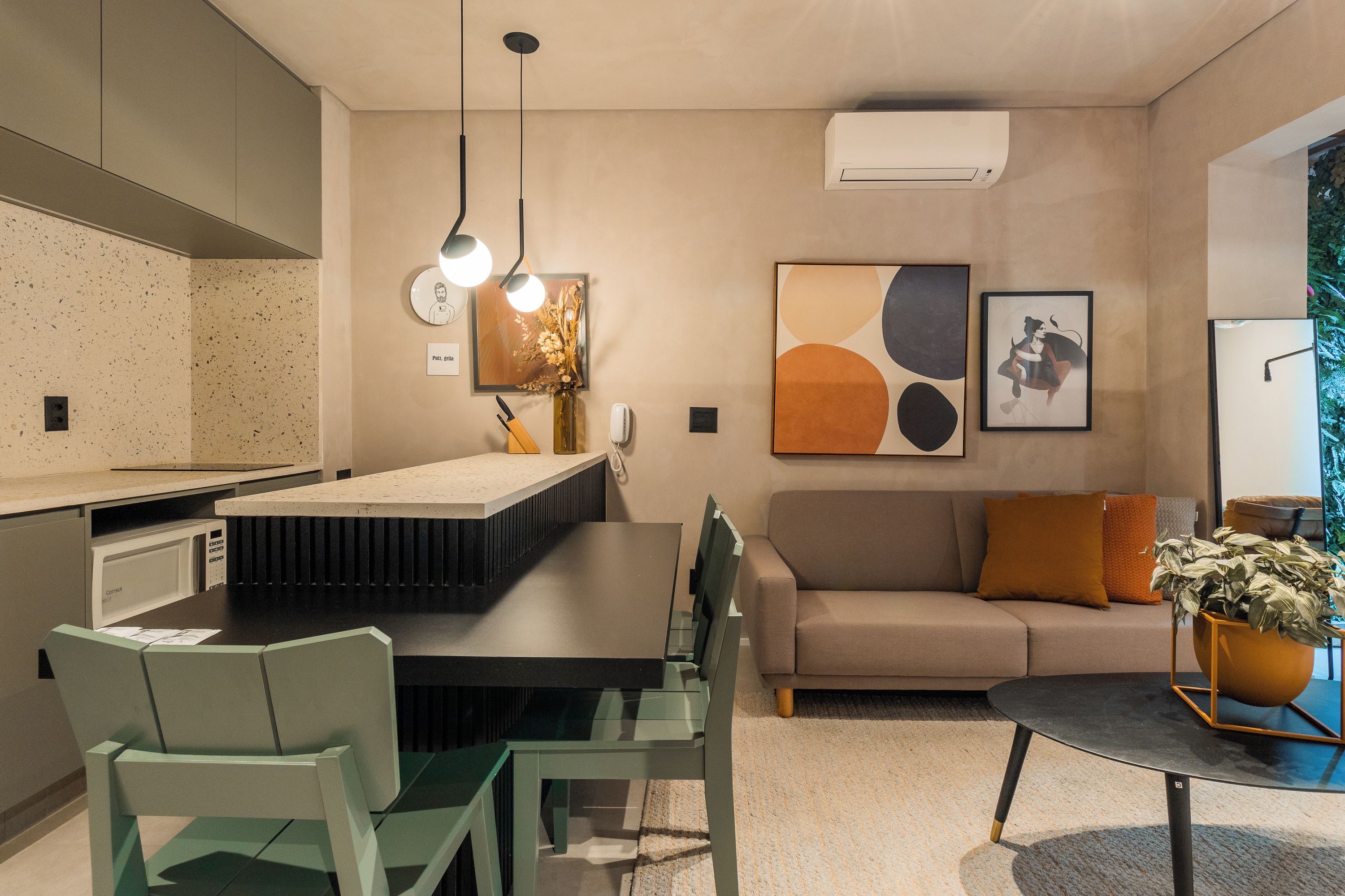 A modern kitchen with a dining area, a sofa, and a coffee table.